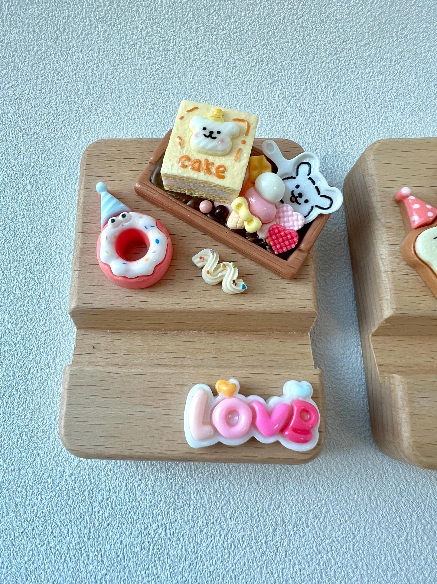 かわいい漫画のチャームで飾られたパーソナライズされた彫刻木製電話スタンド